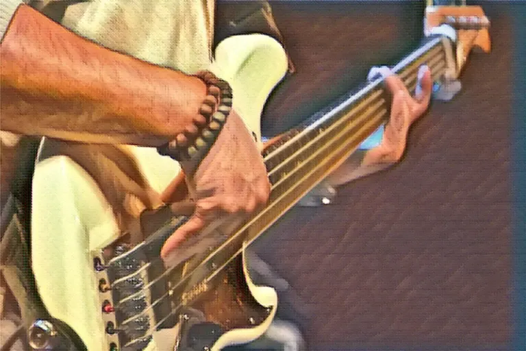 man playing left-handed bass guitar