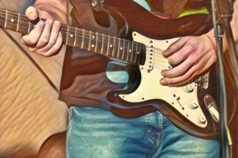 man playing left-handed guitar