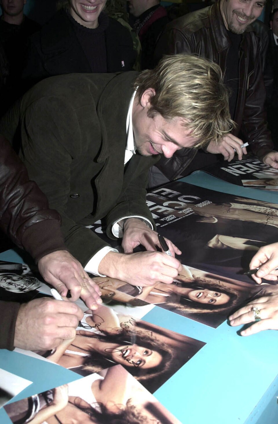 Brad Pitt signing an Ocean's Eleven poster with his right hand at Incirlik Air Base, December 2001