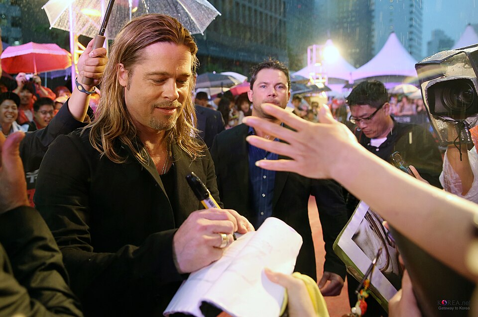Brad Pitt signing an autograph with his right hand at the World War Z premiere in Seoul, June 2013